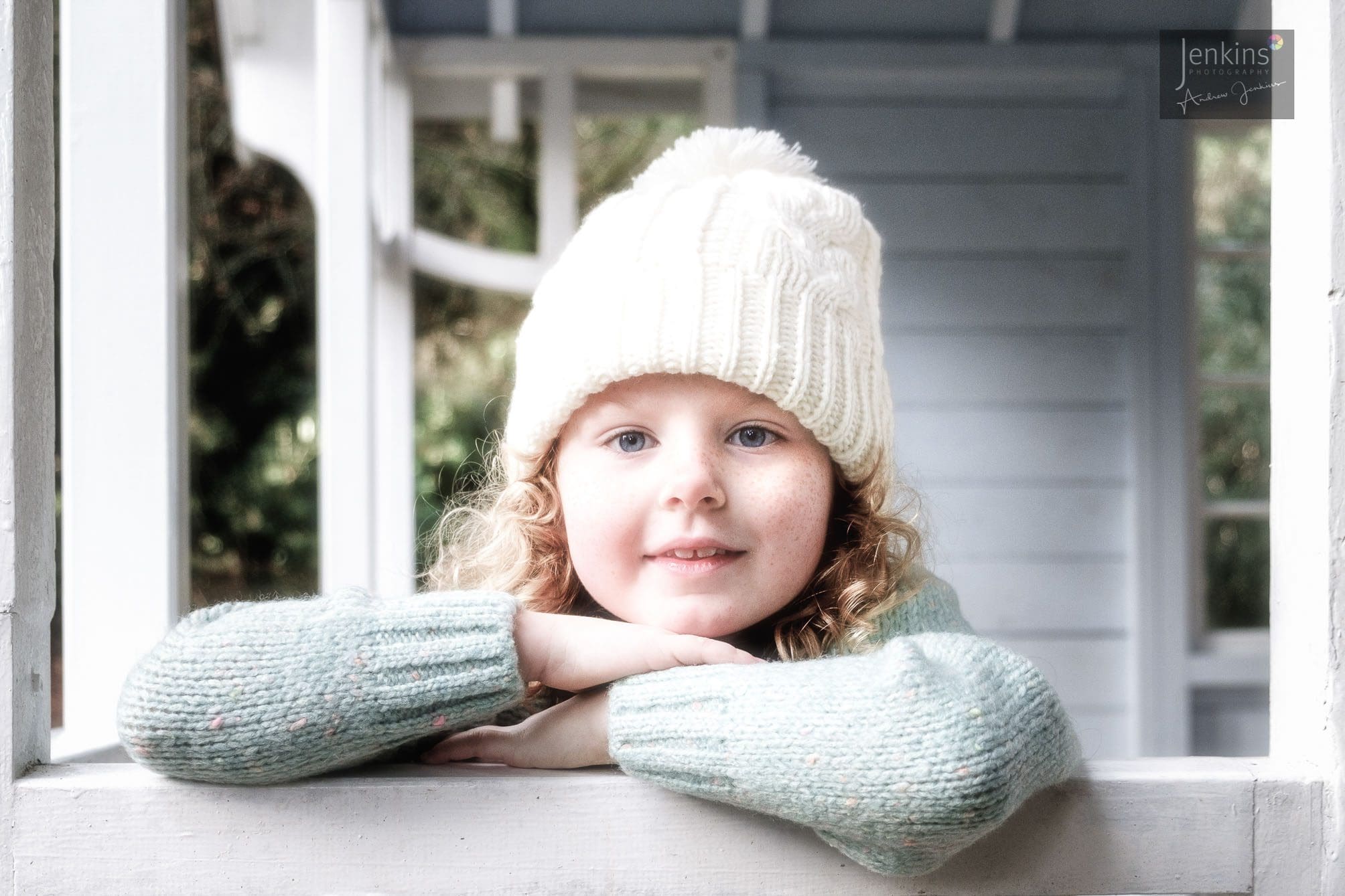 child portrait, green wool jumper, white wooly hat